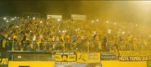 Torcida de amarelo e azul toma comemorando na arquibancada do estádio