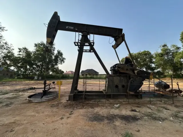 Imashini nyinshi zirimo n’itendetse hejuru za kompanyi Perenco muri Repubulika ya Demokarasi ya Congo. Inyuma kure hari inzu nyinshi n’ibiti.