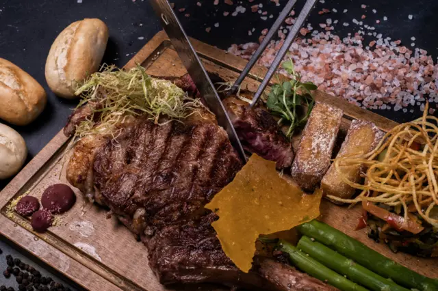 تصویری از استیک سرخ شده همراه با مواد غذایی دیگر