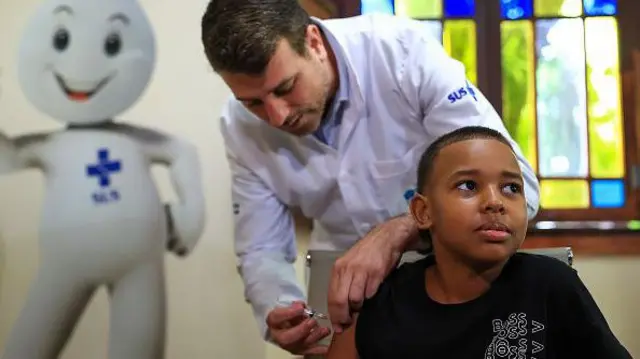 Menino sendo vacinado contra a dengue