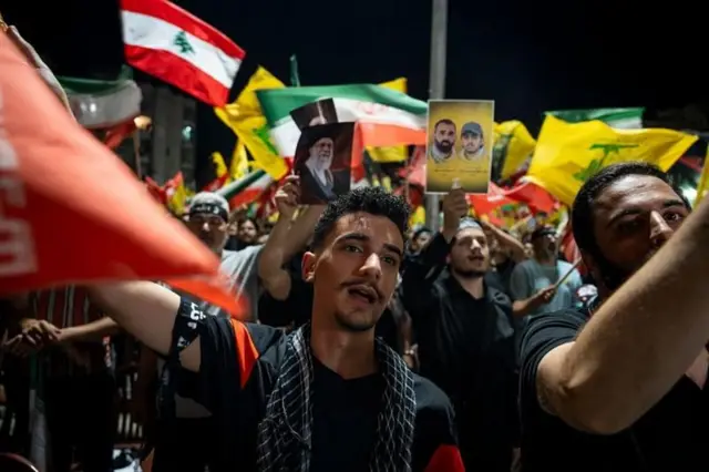 Manifestantes do Hezbollah, com cartazes e bandeiras do Líbano e do Irã