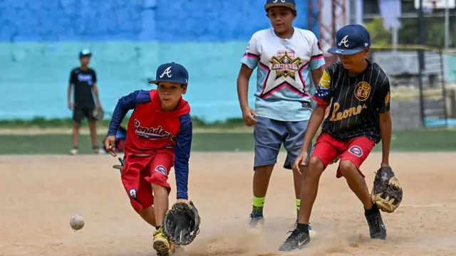 Niños jugando béisbol en un campo de la urbanización 23 de enero de Caracas.