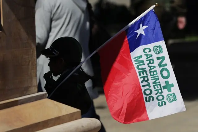 Una niña con una bandera que dice: No más carabineros muertos