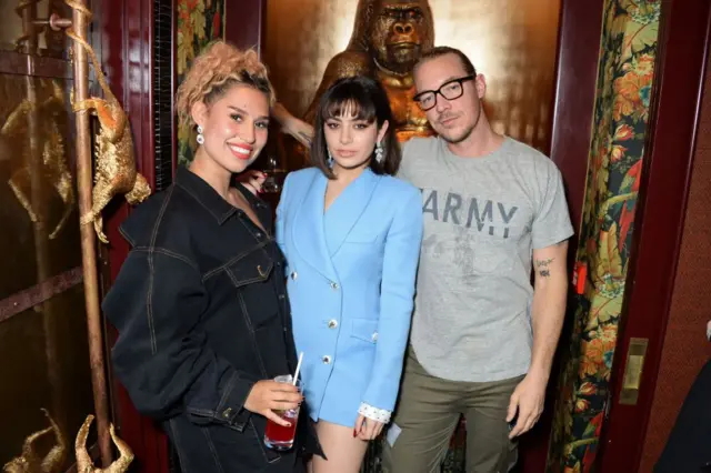 Raye, Charli XCX, and Diplo stand next to each other at the GQ Style and Browns LFWM Party.