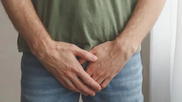 homem vestido com as mãosdicas para apostas esportivas hojefrente ao pênis 