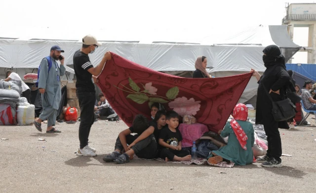 یوه جوړه خپلو ماشومانو ته له یوې کمپلې سیوری جوړوي