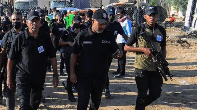 Silahlı ve üniformalı Hamas üyeleri yan yana yürüyor