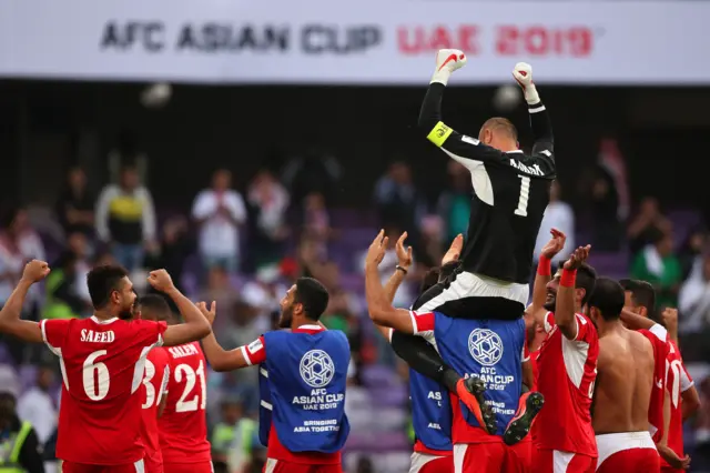 اللاعبون الأردنيون يرفعون الحارس عامر شفيع بعد أدائه الكبير في الفوز على أستراليا في كأس آسيا 2019