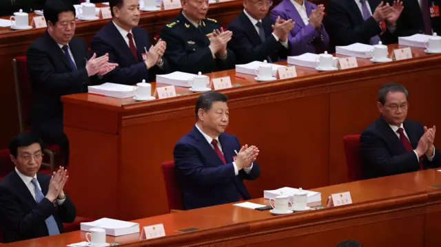 中国国家主席习近平（中）、国务院总理李强（右）及全国政协主席王沪宁（左）在中国第十四届全国人大第四次会议开幕式上鼓掌。