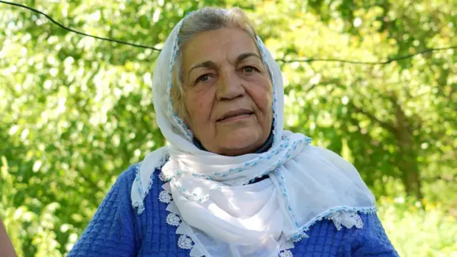 Cemile Hanım'ın fotoğrafı. Beyaz bir başörtüsü, üzerinde mavi uzun kollu kıyafeti var.