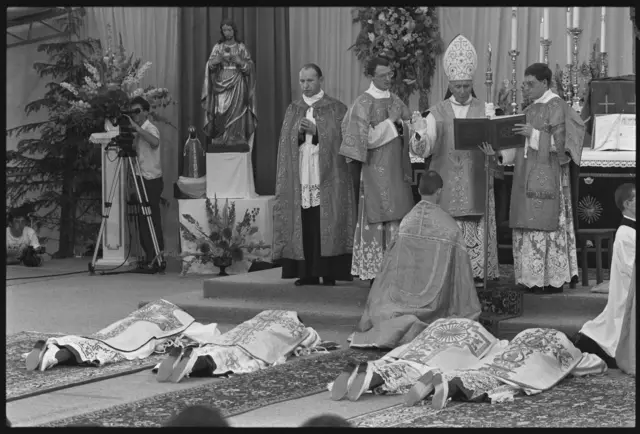 Marcel Lefebvre consagra quatro bispos prostrados diante dele em uma cerimônia em Éconé, na Suíça, em 1988