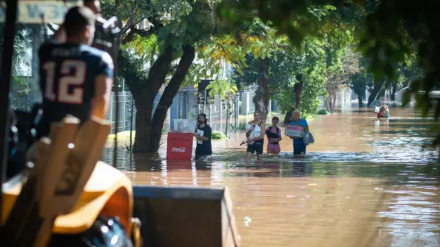 Pessoas carregam sacolas pelas ruas alagadasapostas e prognosticosPorto Alegre