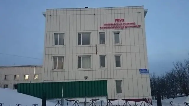 Белое трехэтажное здание с надписью красными буквами