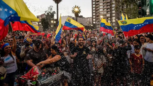 Multidão reunida com bandeiras da Venezuela, em claro ambiente festivo em Santiago do Chile