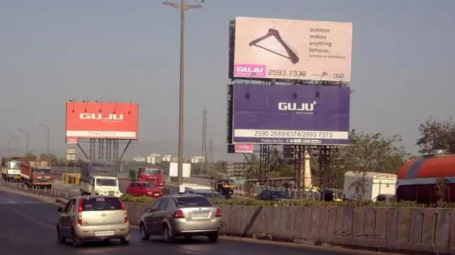 गुजू मीडिया संस्थेचे होर्डिंग 