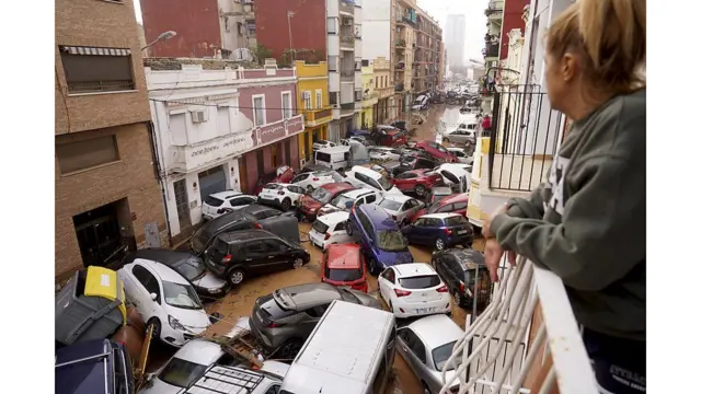 홍수로 뒤엉켜있는 자동차들을 내려다보는 여성