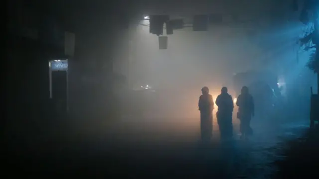 কুয়াশায় হেঁটে যাচ্ছেন তিনজন  