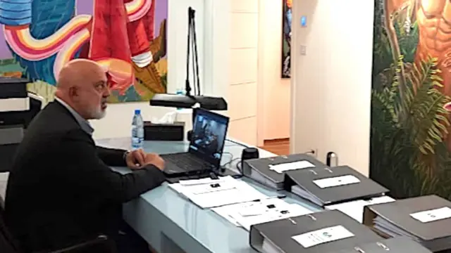 Nazem Said Ahmad za radnim stolom na kom su laptom i brojna dokumenta