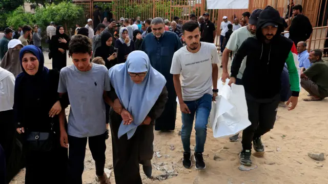 يتفاعل المشيعون خلال جنازة الفلسطينيين الذين قتلوا في الغارات الإسرائيلية الصباحية على الخيام التي تؤوي النازحين، وفقًا للمسعفين، في مستشفى ناصر في خان يونس، جنوب قطاع غزة. 