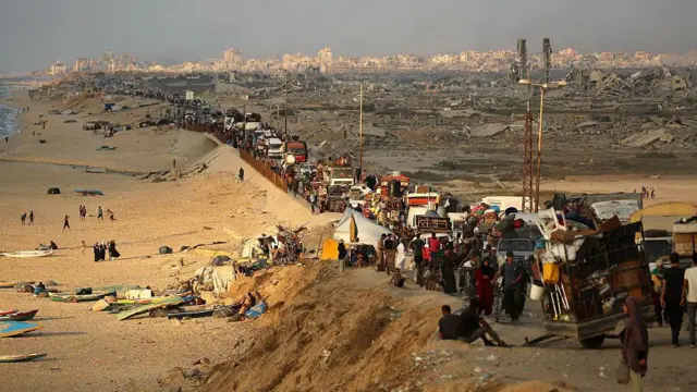 Yerinden edilmiş Filistinliler 24 Eylül 2025'te Gazze Şeridi'nin merkezindeki Nuseyrat mülteci kampı bölgesinde eşyalarıyla birlikte güneye doğru ilerliyor.