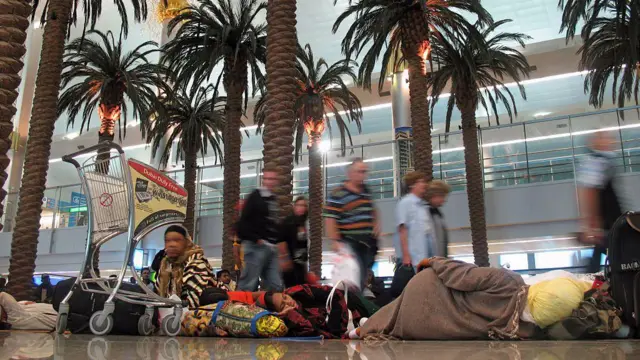 ኣብ ኣህጉራዊ መዓርፎ ነፈርቲ ዱባይ፡ ኣል ጋርሁድ፡ ብዙሓት ነዊሕ ሰዓታት ቀጻሊ ጉዕዞ ዝጽበዩ ገያሾ ኣብቲ መዕርፎ ነፈርቲ ኣብ መሬት ደቂሶም ይርኣዩ