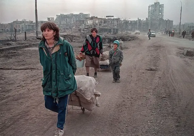 Жители выходят из разбомбленного Грозного