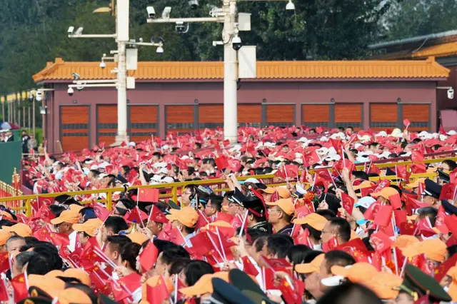 阅兵式前，参加者在天安门广场挥舞着中国国旗。