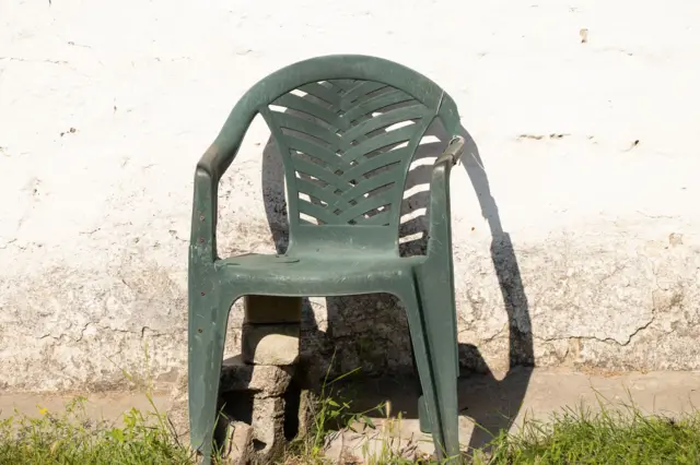 Una silla Monobloc rota.