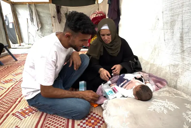 رجل وامرأة وطفلهما الرضيع.