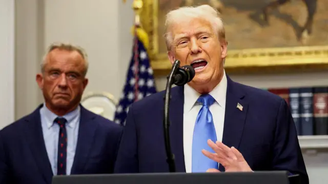 Donald Trump fala de uma tribuna durante uma entrevista coletiva na Casa Branca, acompanhado por Robert F. Kennedy Jr. 