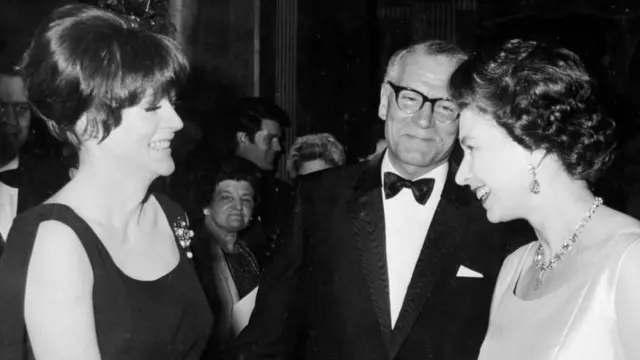 La reina Isabel II siendo presentada a Maggie Smith por Laurence Olivier en el estreno benéfico de la película "Otelo" en Londres en 1966.