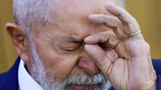 Lula segura a cabeça com os dedos das mãos em uma expressão de sofrimento