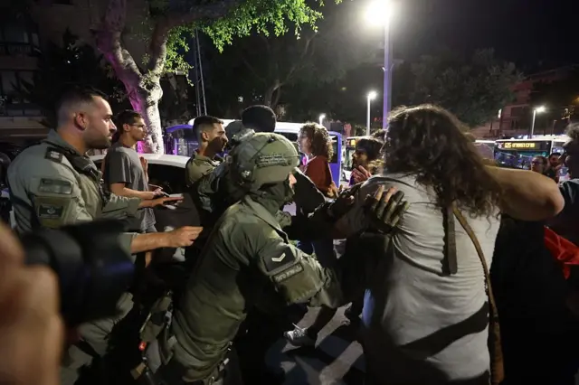 Bir polis göstericiye müdahale ediyor