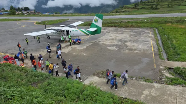 हुम्लामा अवतरण गरेको यती एअरलाइन्सको विमान र त्यसबाट ओर्लिएका तीर्थयात्रीहरू 