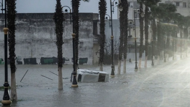سيارة عالقة وسط مياه الفيضان بعد أن غمرت المياه المنازل في القصر الكبير بالمغرب، في 30 يناير/كانون الثاني 2026.