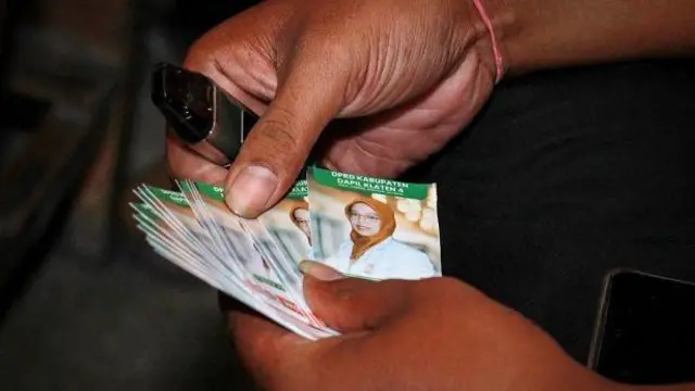 Warga menunjukkan kartu bergambar Lingga Permesti, calon anggota legislatif Partai Keadilan Sejahtera Islam (PKS) di Klaten, Jawa Tengah.