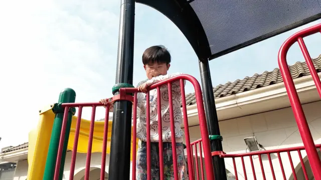 Aiden在玩樂設施上休息。