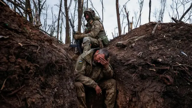 Ukrainian servicemen rest at their positions after a fight