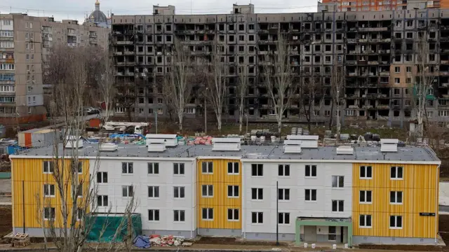 New apartment block next to housing ruined by shelling in Mariupol, 2023 