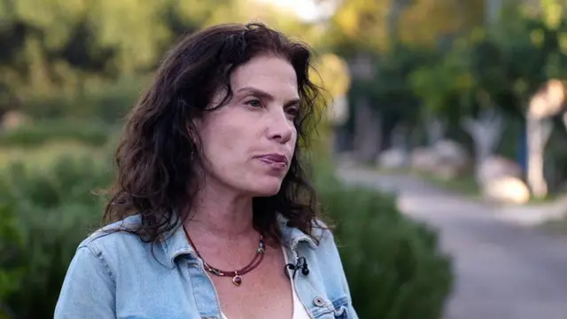 صورة الدكتورة ليا نوَر تقف في حديقة.