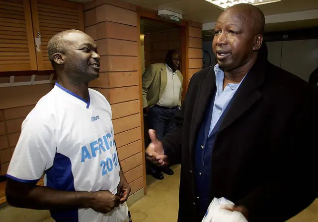 Le footballeur malien Salif Keita (à droite) discute avec l'ancien attaquant camerounais Roger Milla en 2004.