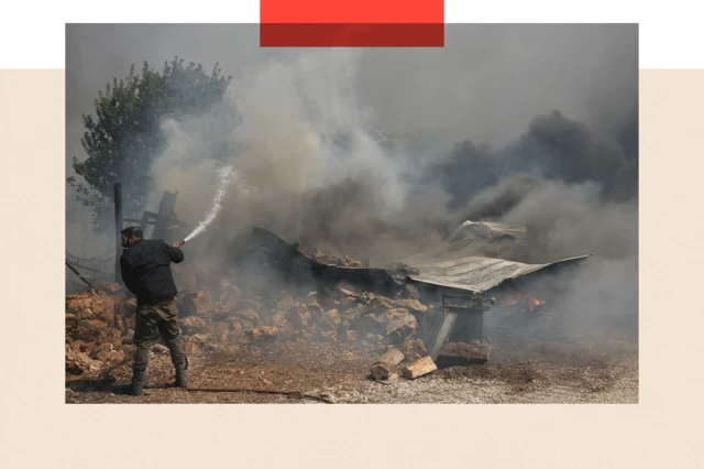 Un homme tente d'éteindre le feu qui brûle une maison à Nea Penteli, en Grèce.