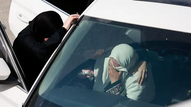 Arabanın içinden ve dışında ağlayan iki kadın. 
