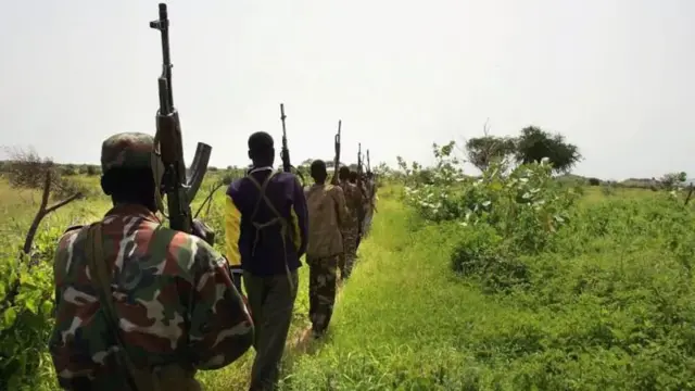 Wasu mutane riƙe da makamai sun yi layi suna tafiya sun juya baya