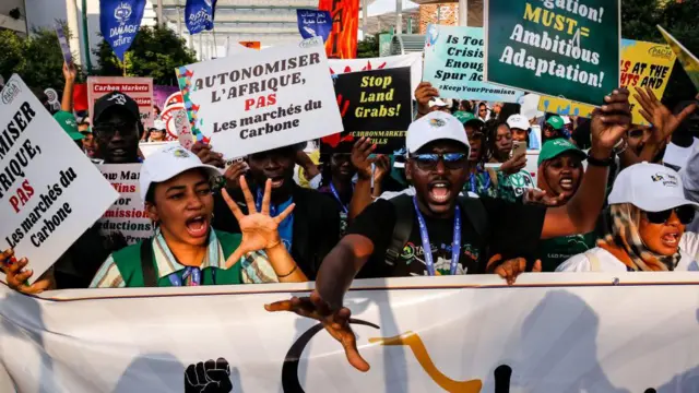 Protestors carry signs and banners outside COP28