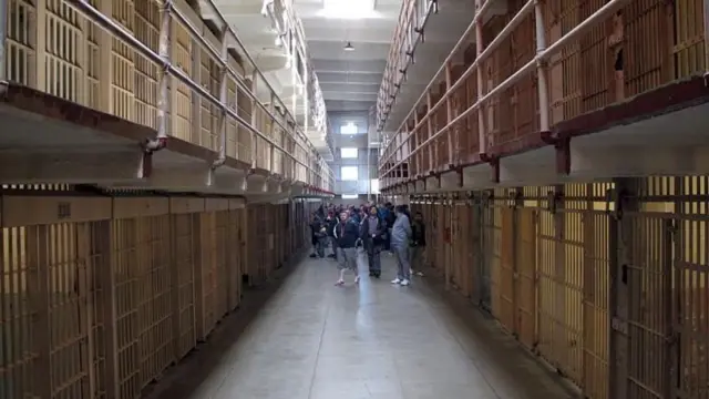 Visitantes observam as celas vazias da antiga prisão de Alcatraz