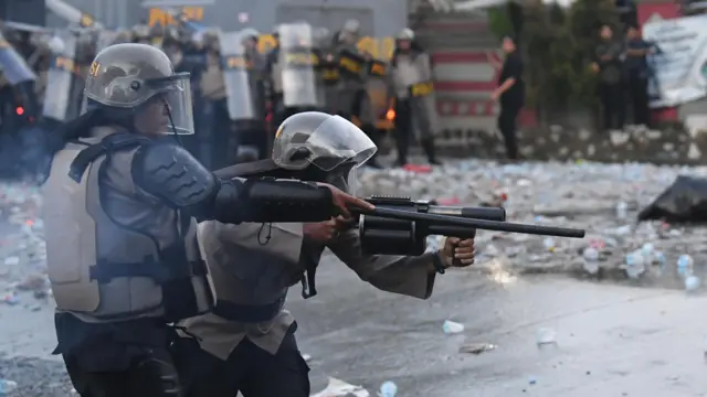 Polisi menembakkan gas air mata menghalau unjuk rasa.