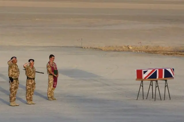 سربازان بریتانیا در مقابل یک تابوت ایستاده ‌اند