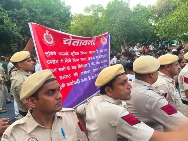 दिल्ली पोलीस बॅनरच्या माध्यमातून आंदोलकांना आंदोलनस्थळ खाली करण्यास सांगताना