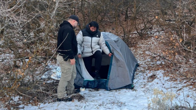 Kai Zhuang saindoaposta no cassinobarracaaposta no cassinoacampamento, observado por um homem